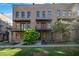 Brick townhome exterior with balconies, landscaping, and manicured lawn at 1048 Claudette Colvin Ct, Atlanta, GA 30318