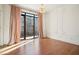 Sunlit bedroom with a balcony, wood floors and a stylish chandelier at 1199 Huff Nw Rd # 127, Atlanta, GA 30318