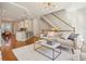 Bright living room features hardwood floors, modern lighting, and staircase access, adjacent to an open kitchen at 1199 Huff Nw Rd # 127, Atlanta, GA 30318