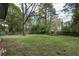 Spacious backyard with scattered grass and several trees surrounding the yard's perimeter at 1809 San Gabriel Ave, Decatur, GA 30032