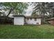 View of the backyard featuring a white brick home and overgrown grass at 1809 San Gabriel Ave, Decatur, GA 30032