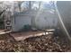View of the back of the one-story house with brick patio, small yard and mature trees at 2168 Clanton Ter, Decatur, GA 30034