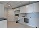 Bright laundry room with white cabinets, sink and door to the exterior at 750 Park Ne Ave # 13E, Atlanta, GA 30326