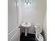 Cozy powder room with a pedestal sink, modern lighting, and a convenient layout at 7744 Sudbury Cir, Covington, GA 30014