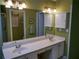 Bathroom featuring double sinks, vanity with storage, and updated light fixtures at 1042 Pecan Grove Pl, Lawrenceville, GA 30046