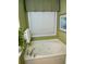 Corner bathtub with jacuzzi jets, window view, and white finish at 1042 Pecan Grove Pl, Lawrenceville, GA 30046