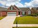 Charming brick home featuring an attached two-car garage and a beautifully manicured lawn at 1042 Pecan Grove Pl, Lawrenceville, GA 30046