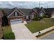 Inviting brick home with a two-car garage, complemented by a lush green lawn and colorful flower beds at 1042 Pecan Grove Pl, Lawrenceville, GA 30046