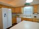 Functional kitchen featuring oak cabinets, white appliances, and a tile backsplash at 1042 Pecan Grove Pl, Lawrenceville, GA 30046