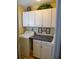 Laundry room with white cabinets, countertop, and included washer and dryer at 1042 Pecan Grove Pl, Lawrenceville, GA 30046