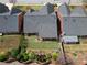 Aerial view of home's back exterior featuring a manicured lawn, covered patio, and beautiful landscaping at 1042 Pecan Grove Pl, Lawrenceville, GA 30046