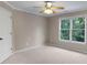 Carpeted bedroom features a ceiling fan and a window with green outdoor views at 2788 Bridle Ridge Way, Buford, GA 30519