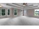 Large bedroom with tray ceilings, fan, and multiple windows providing ample light at 2788 Bridle Ridge Way, Buford, GA 30519