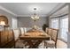 Elegant dining room with a large wooden table, chandelier, and natural light from bay window at 2788 Bridle Ridge Way, Buford, GA 30519