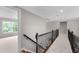 Upstairs hallway with black railing, showing bedroom with large window at 2788 Bridle Ridge Way, Buford, GA 30519