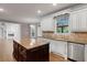 Kitchen featuring a dark island, white cabinets, stainless appliances, and hardwood floors at 2788 Bridle Ridge Way, Buford, GA 30519