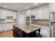 Bright kitchen with white cabinets, a dark island, stainless appliances, and hardwood floors at 2788 Bridle Ridge Way, Buford, GA 30519