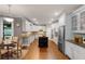Open kitchen featuring white cabinets, stainless appliances, a dark island, and hardwood floors at 2788 Bridle Ridge Way, Buford, GA 30519