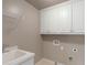 Neat laundry area features cabinets and a sink with stainless steel faucet at 2788 Bridle Ridge Way, Buford, GA 30519