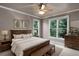 Bedroom with natural light, a wooden bed frame, a ceiling fan, and neutral color palette at 2788 Bridle Ridge Way, Buford, GA 30519