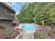 An outdoor swimming pool with umbrellas and lounge chairs is surrounded by trees and lush landscaping at 2788 Bridle Ridge Way, Buford, GA 30519