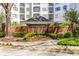 Charming entrance to The Prescott at Park Place, featuring brick architecture and lush landscaping at 11 Perimeter E Ctr # 1404, Atlanta, GA 30346