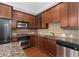A kitchen showcasing wood cabinets, granite countertops, stainless steel appliances, and tiled backsplash at 11 Perimeter E Ctr # 1404, Atlanta, GA 30346