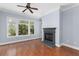 A bright living room featuring large windows, a ceiling fan, fireplace, and hardwood floors at 11 Perimeter E Ctr # 1404, Atlanta, GA 30346