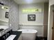 Elegant bathroom with a freestanding tub, modern fixtures, and unique wallpaper design at 3658 Brock Rd, Duluth, GA 30096