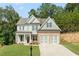New two-story home with stone accents, well-manicured lawn, and a wide driveway leading to a two-car garage at 699 Crest Line W Trl, Powder Springs, GA 30127