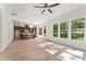 Open floor plan showcasing light hardwood floors, abundant natural light from large windows, and a view into the modern kitchen at 699 Crest Line W Trl, Powder Springs, GA 30127