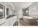 Bright bathroom with double vanity, a tub with stone surround, and glass-enclosed shower at 1395 Crestwind Nw Rd, Kennesaw, GA 30152