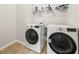 Well-lit laundry room with modern washer and dryer, plus storage shelf at 1395 Crestwind Nw Rd, Kennesaw, GA 30152