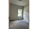 Cozy bedroom with plush gray carpeting and a bright window view at 3908 Shelleydale Dr, Powder Springs, GA 30127
