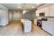 Modern kitchen with an island and stainless steel appliances flows into a spacious living area with hardwood floors at 3908 Shelleydale Dr, Powder Springs, GA 30127