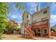 A spacious backyard has a two-story deck, a small staircase, and lush greenery at 1455 Oglethorpe Run Ln, Suwanee, GA 30024