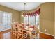 Bright dining room featuring a wood table with seating for six, hardwood floors, and a large window at 1455 Oglethorpe Run Ln, Suwanee, GA 30024