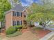 Charming two-story brick home with a well-manicured lawn and mature landscaping, inviting curb appeal at 1455 Oglethorpe Run Ln, Suwanee, GA 30024