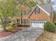 Charming two-story brick home featuring a two-car garage and mature landscaping at 1455 Oglethorpe Run Ln, Suwanee, GA 30024