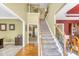 Spacious foyer featuring a carpeted staircase, hardwood floors, and views into other rooms at 1455 Oglethorpe Run Ln, Suwanee, GA 30024