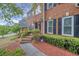 Attractive brick front entrance with black shutters, beautiful shrubbery, and a welcoming walkway at 1455 Oglethorpe Run Ln, Suwanee, GA 30024