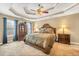 Main bedroom boasts a decorative ceiling, large windows, and carpet flooring at 1455 Oglethorpe Run Ln, Suwanee, GA 30024
