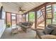 The enclosed sunroom has a ceiling fan, wicker furniture, and outdoor views at 1455 Oglethorpe Run Ln, Suwanee, GA 30024
