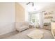 Charming bedroom with a crib, rocking chair, books, and wood accent wall creating a comforting and stylish space at 3065 Windcrest Ct, Alpharetta, GA 30022