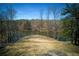 Expansive lakefront backyard offering privacy and serene water views on a sunny day at 1280 Tynecastle Way, Sandy Springs, GA 30350