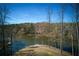Expansive lakefront backyard offering privacy and serene water views on a sunny day at 1280 Tynecastle Way, Sandy Springs, GA 30350