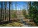Scenic drive leading to a lakefront property surrounded by trees and natural beauty at 1280 Tynecastle Way, Sandy Springs, GA 30350