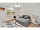 Bright bedroom features hardwood floors, a gray sofa, and a window with plantation shutters at 2376 Academy Ne Ct, Atlanta, GA 30345