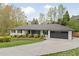 Classic one-story home with a modern color scheme, black trim, a well-kept lawn, and a wide driveway at 2376 Academy Ne Ct, Atlanta, GA 30345