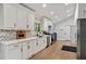 Bright kitchen features white cabinets, stainless appliances, chevron backsplash and quartz countertops at 2376 Academy Ne Ct, Atlanta, GA 30345